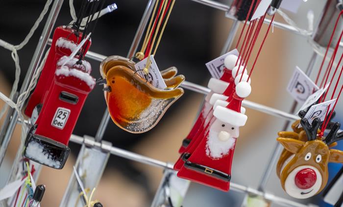 Close up of handmade Christmas decorations hanging on a stall display.